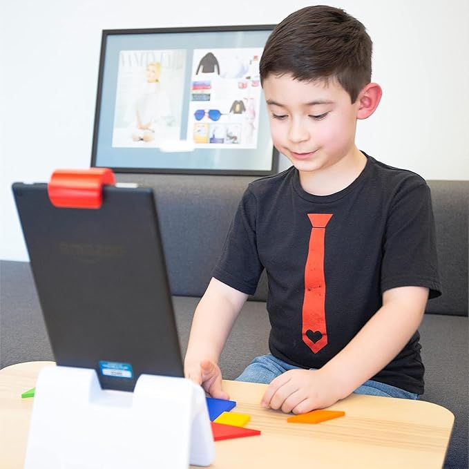 A boy playing Osmo Tangram with the wooden pieces in front of his Fire tablet on the Osmo base