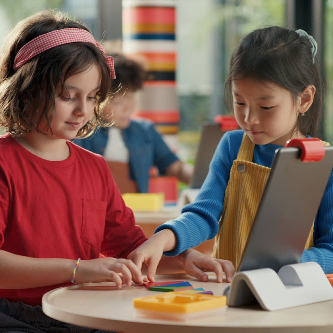 Two children playing Osmo Tangram side by side