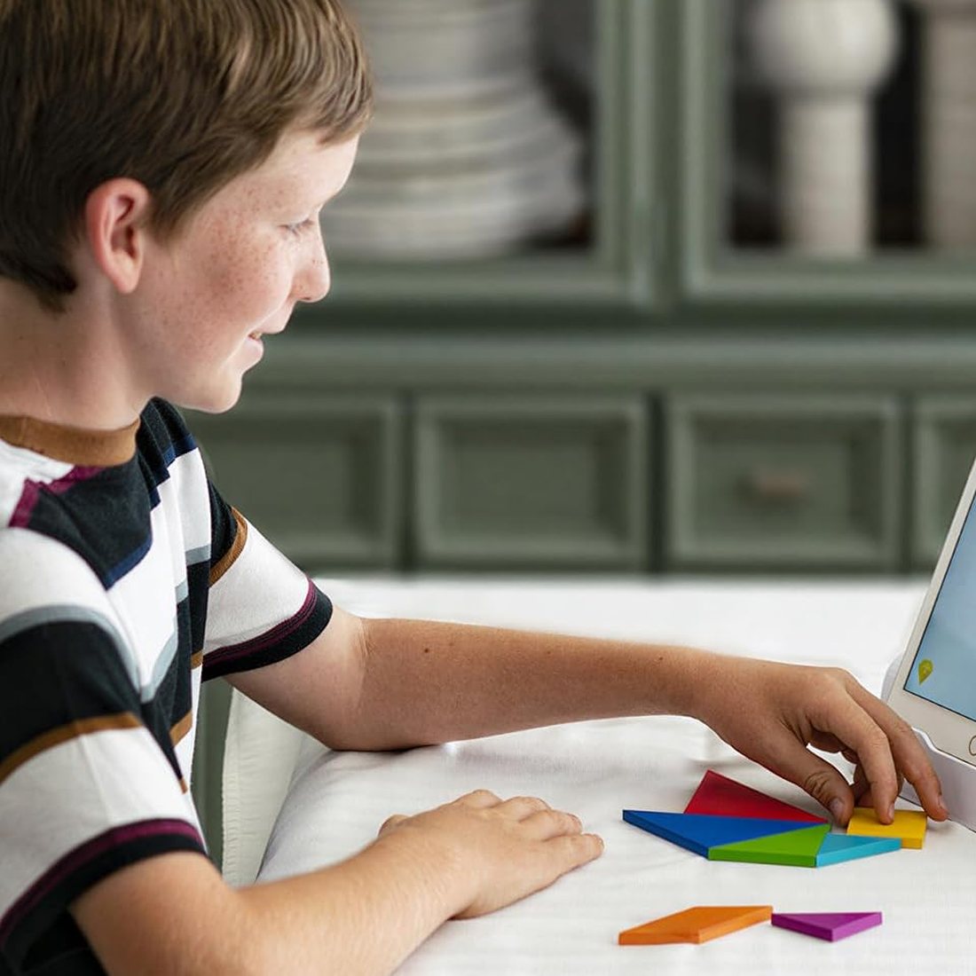 A child happily playing Osmo Tangram at home